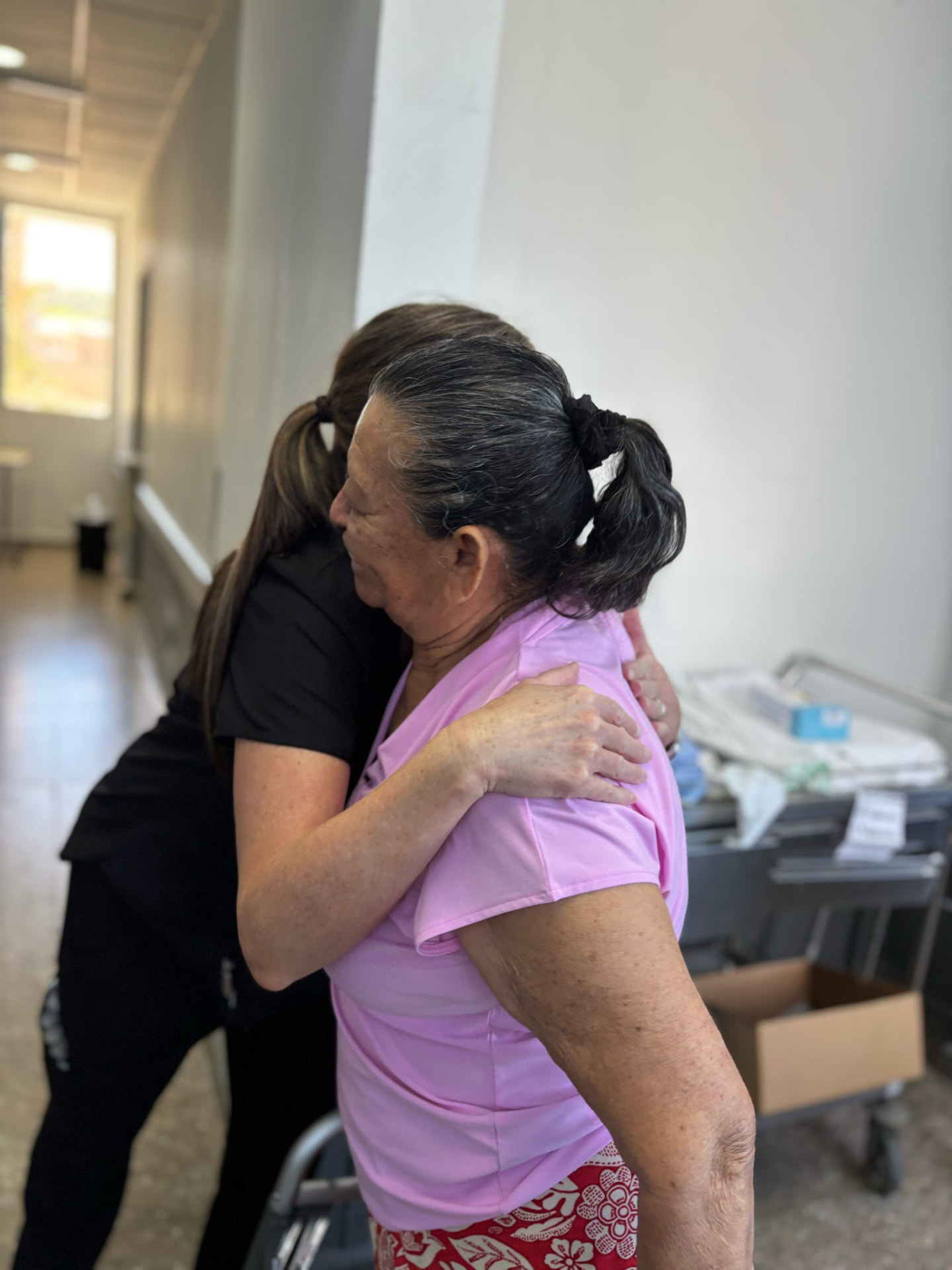 A patient and a caregiver sharing an emotional embrace after surgery